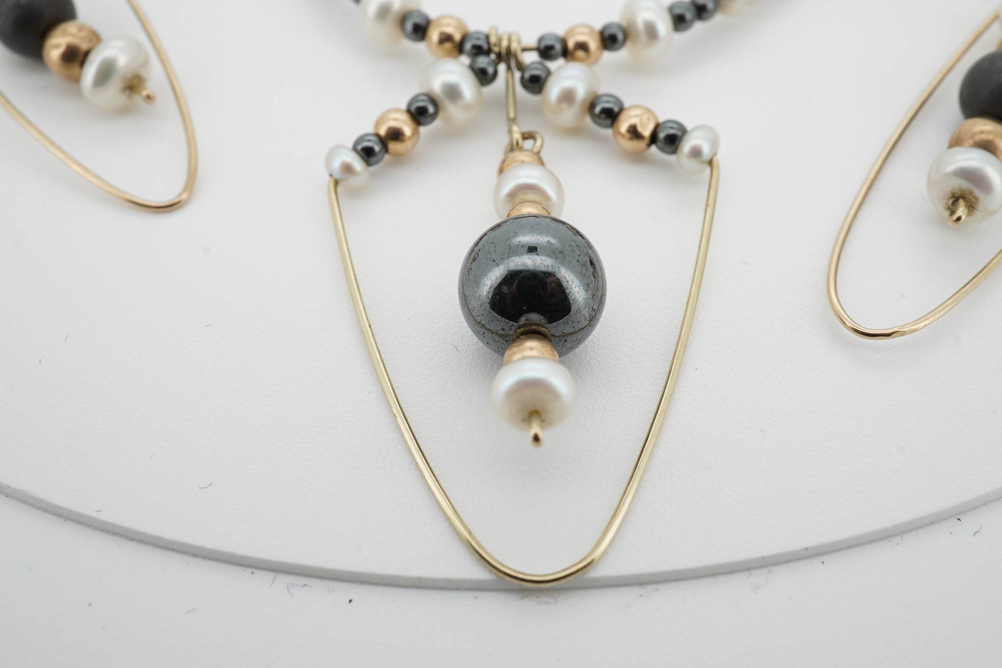 A modern Uno-A-Erre 9ct gold seed pearl and hematite cluster set necklace, approx. 40cm, with a pair of similar drop earrings, gross weight 10 grams. Condition - fair